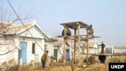 북한 약수협동농장 농장원들이 유엔개발계획(UNDP) 지원으로 온수 생산을 위한 태양전지판을 설치하고 있다. UNDP 제공.