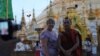 A western tourist poses for a photograph with a Buddhist monk at the Shwedagon Pagoda in Rangoon, Burma, May 31, 2012.