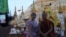 A western tourist poses for a photograph with a Buddhist monk at the Shwedagon Pagoda in Rangoon, Burma, May 31, 2012.