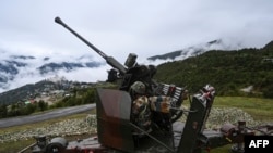 资料照：中印边界争议地区实际控制线（LAC）附近的一名印度士兵在L70高射炮炮位上。（2021年10月20日）