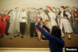 中国全国人大会议期间的一个小组讨论会会场，有记者拍摄一幅描绘毛泽东主席会见各民族群众的画。（2018年3月8日））