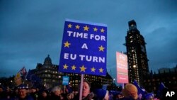 Pro-European demonstrators hold posters at Parliament Square in London, Jan. 15, 2019.