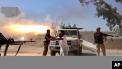 Des combattants de la Brigade Misarata tirent en direction de l'aéroport de Tripoli, Libye, 26 juillet 2014.