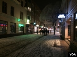 Despite police warnings that women should not go out alone at night for safety, groups of party goers slide in the snow from restaurants to bars to clubs late into Saturday night as the night walkers patrol, Ostersund, Sweden, March 19, 2016. (Heather Murdock/VOA)