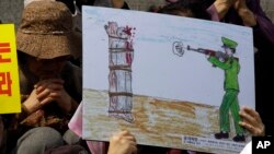 지난 2011년 4월 서울에서 열린 북한 인권 시위에서 한 탈북자가 공개 사형집행 그림을 들고 있다. (자료사진)