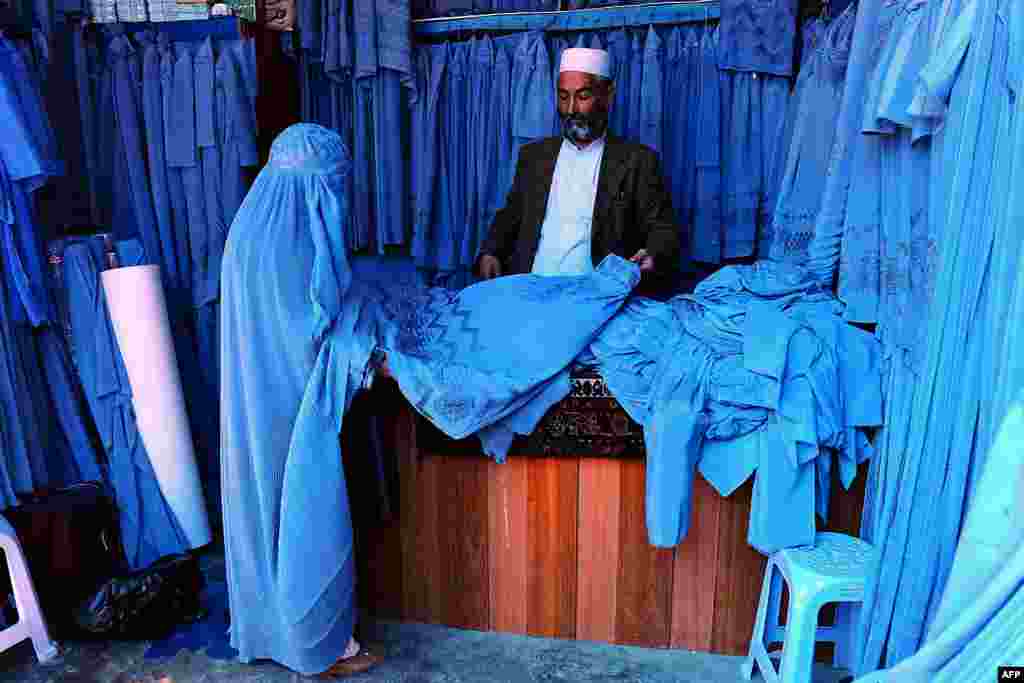 Seorang perempuan Afghanistan memilih-milih &#39;burqa&#39; pada sebuah bazaar di kota Herat.