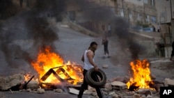 在以色列军队袭击西岸城市纳布卢斯期间，巴勒斯坦人焚烧轮胎。（2015年10月6号）