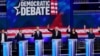 FILE - Democratic presidential candidates raise their hands during the Democratic primary debate at the Adrienne Arsht Center for the Performing Arts in Miami, Florida, June 27, 2019.