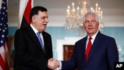 美国国务卿蒂勒森与来访的利比亚总理萨拉杰在美国国务院与媒体见面时握手。（2017年12月1日）