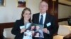 Melissa Rhodes-Smith and Geoff Rhodes hold a photo of Gavin Rhodes and his wife, Phoumalaysy and their children, in Vientiane, Laos, Nov. 28, 2014. (Ron Corben/VOA)