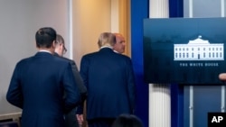 President Donald Trump is asked to leave the James Brady Press Briefing Room by a member of the U.S. Secret Service during a news conference at the White House, Aug. 10, 2020.