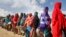 Newly-arrived women who fled drought queue to receive food distributed by local volunteers at a camp for displaced persons in the Daynile neighborhood on the outskirts of the capital Mogadishu, in Somalia, May 18, 2019. 