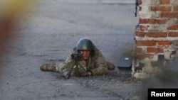 15일 우크라이나 동부 크라마토르스크 공항에서 한 군인이 친러 무장 세력을 향해 총을 겨누고 있다. 우크라이나 군은 친러 세력이 장악했던 공항을 탈환했다.