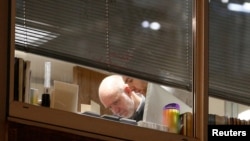 在调查人员进入剑桥分析伦敦办公室之际，人们可以看到楼内有人。（2018年3月23日）