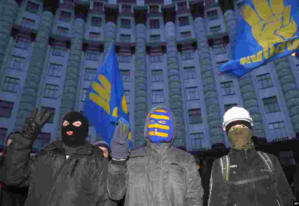 Para demonstran berdiri di depan gedung Kabinet di Kiev (2/12). (AP/Sergei Grits)