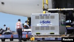 台湾工人在桃园国际机场从日本飞机上卸下日本捐赠的新冠病毒疫苗。（2021年7月8日）