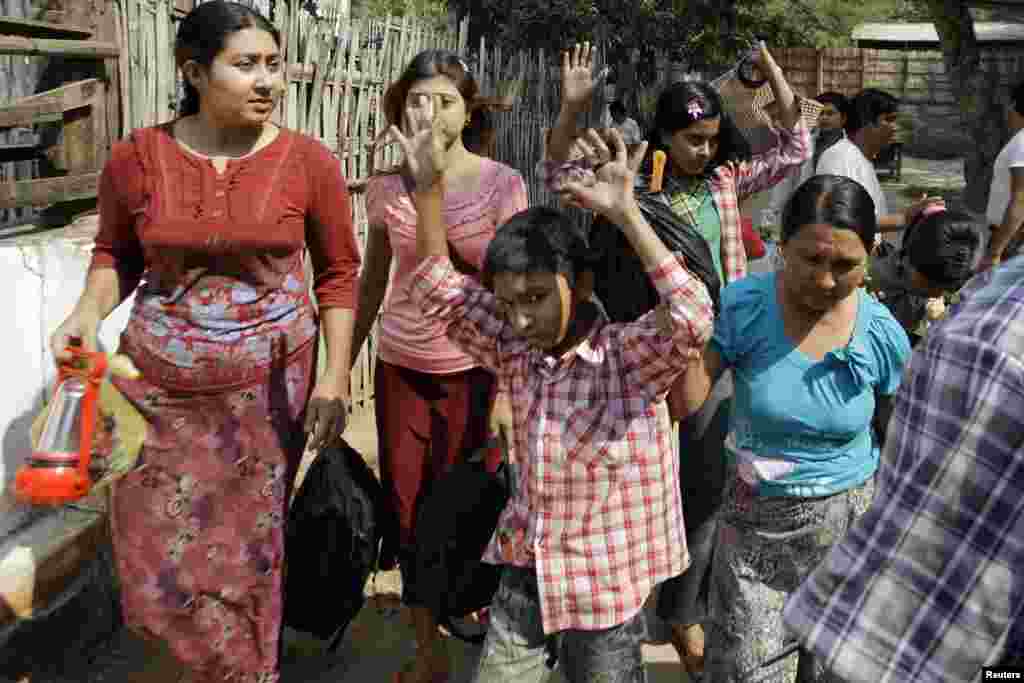 Muslims emerge from their homes after a senior Buddhist monk and police arrived to protect them amid riots in Meikhtila March 22, 2013.