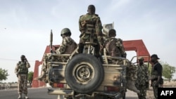 Des soldats de la 7e division de l'armée nigériane se préparent à quitter Maiduguri dans un convoi lourdement armé sur la route de Damboa dans l'Etat de Borno, au nord-est du Nigeria, le 25 mars 2016.