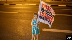 A girl holds a flag during a protest near the square outside Israeli Prime Minister Benjamin Netanyahu's residence in Jerusalem on Sept. 6, 2020.