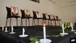 Framed photographs of seven crew members are displayed at a memorial service held by an association of Ethiopian airline pilots, in Addis Ababa, Ethiopia Monday, March 11, 2019. (AP Photo/Samuel Habtab)