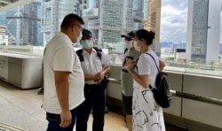 有警长在高等法院门外，与要求重判唐英杰的亲中人士商讨示威安排 （美国之音/汤惠芸）