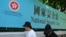资料照：行人走过香港街头港版国安法的宣传牌。（2020年7月15日）