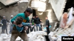 2月2号阿萨德军队轰炸阿勒颇，一名男子怀抱从瓦砾下挖出的一名受伤的孩子。