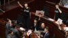 Pro-democracy lawmakers protest as Chief Executive Carrie Lam delivers a speech in Hong Kong, Oct. 16, 2019. Chanting pro-democracy lawmakers have interrupted the start of a speech that Lam was giving laying out her policies.