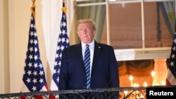 特朗普总统乘坐“海军陆战队一号”总统专用直升机沃尔·里德国家医疗中心返回白宫，站在杜鲁门阳台上。(2020年10月5日) 