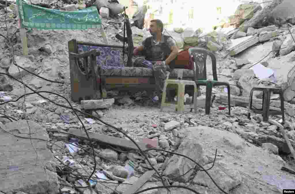 Seorang anggota Tentara Pembebasan Suriah duduk di sofa di sebuah jalan di daerah Salaheddine, Aleppo (30/7).&nbsp;