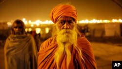 A Hindu holy man stands at Sangam, the confluence of the rivers Ganges, Yamuna and the mythical Saraswati during the annual traditional fair of Magh Mela, in Allahabad, India, Feb. 14, 2014.