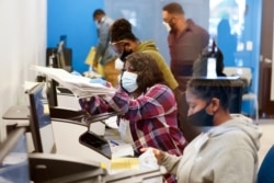 FILE - Officials work on ballots at the Gwinnett County Voter Registration and Elections Headquarters, Nov. 6, 2020, in Lawrenceville, near Atlanta, Georgia.