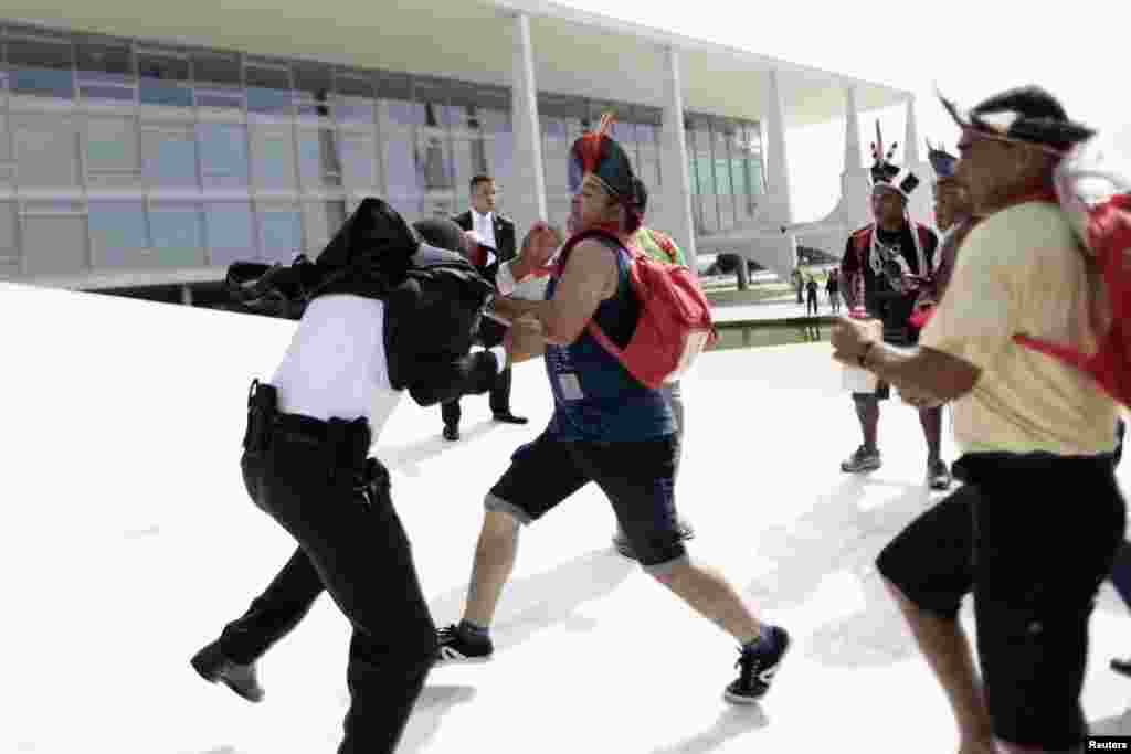 Warga suku asli Brazil bentrok dengan polisi di Planalto Palace di kota Brasilia, Brazil, dalam aksi protes menentang pembatasan tanah adat suku Indian di sana. 