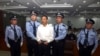FILE - In this photo released by the Jinan Intermediate People's Court, fallen politician Bo Xilai, center, is handcuffed and held by police officers as he stands at the court in Jinan, in eastern China's Shandong province, Sept. 22, 2013. 