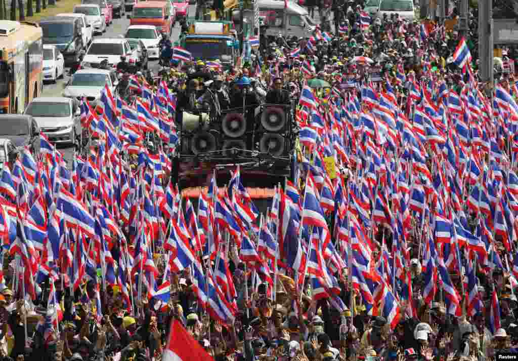 Ribuan demonstran anti pemerintah Thailand berpawai dengan membawa bendera nasional menuju Departemen Khusus Investigasi (DSI) di ibukota Bangkok.