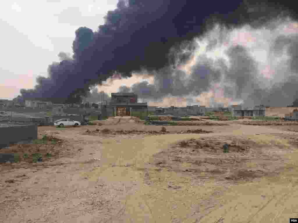 Asap membubung dari sumur-sumur minyak yang dibakar kelompok militan Negara Islam (ISIS) beroperasi di pinggiran kota Qayyarah, Irak (24/10). (VOA/H. Murdock)