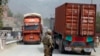 FILE - U.S. soldier watches trucks crossing Torkham gate border between Afghanistan and Pakistan in Nangarhar province, Afghanistan.