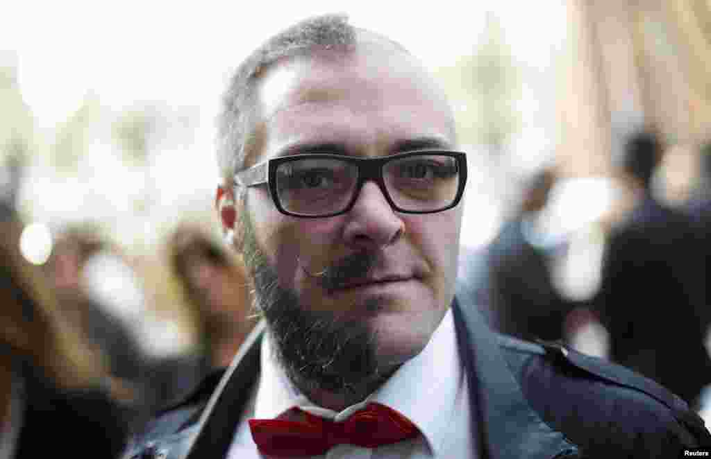 A Yeoman Warder walks through ceramic poppies that form part of the art installation "Blood Swept Lands and Seas of Red" at the Tower of London in London Oct. 29, 2014. Each poppy represents a soldier killed during the WWI. 