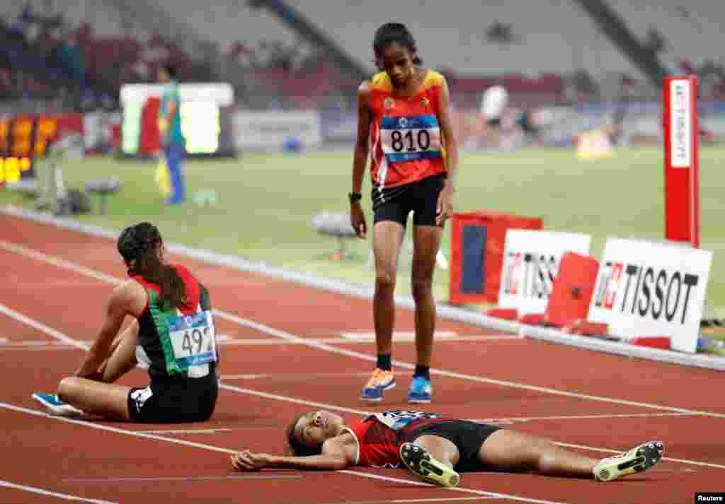Odekta Elvina Naibaho of Indonesia collapses after the women's 5,000 meter run final during the 2018 Asian Games in Jakarta, Indonesia.