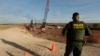 A U.S. Border Patrol agent stands over a construction site for a new section of levee border wall along the U.S.-Mexico border, Nov. 7, 2019, in Donna, Texas. 