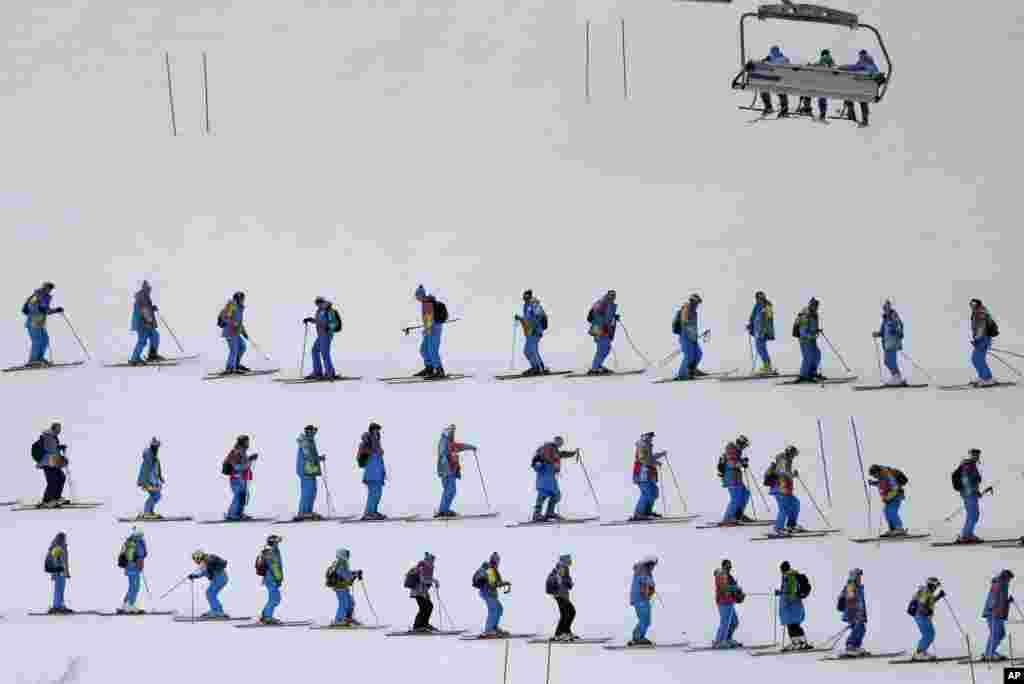 14일 여성 활강스키 경기에 앞서 인부들이 스키장 경사면을 고르고 있다.