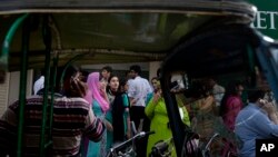 People evacuate buildings and gather on road after an earthquake was felt in Karachi, Pakistan, April 16, 2013. 