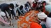 Family members and relatives pray after burying a person who died of reasons other than COVID-19 in a shallow sand grave on the banks of river Ganges in Prayagraj, India, May 16, 2021.