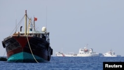 中国一艘渔船2017年4月5日停泊在南中国海的黄岩岛附近，旁边是中国的海警船。