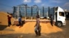 FILE - Thai workers unload rice from the truck of a farmer, at a rice collection center, in the northeastern province of Roi Et , in Thailand. 