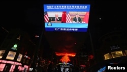 2021年11月16日，北京的户外显示屏上播放中国中央电视台有关国家主席习近平与美国总统拜登视频会议的报道。