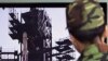 South Korean Army soldiers watch a TV news program which shows North Korea's Unha-3 rocket at Seoul train station in Seoul, South Korea, April 9, 2012