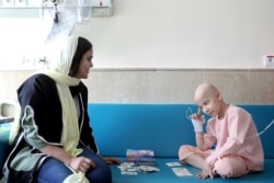 Taha Shakouri, an 8-year-old boy suffering from liver cancer, plays cards at Mahak Children's Hospital in Tehran, June 19, 2019.