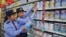 FILE - Chinese commercial law enforcement personnel inspect milk powder products at a supermarket in Lianyungang, Jiangsu province, China.