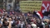Supporters of Egyptian President-elect Mohamed Morsi rally in front of a banner rejecting recent military edicts at Tahrir square in Cairo, June 26, 2012. 
